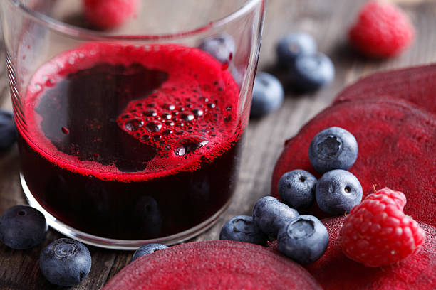 Vaso de jugo de arándano rojo junto a cápsulas de proantocianidinas, ilustrando la falta de estandarización según la EAU 2025